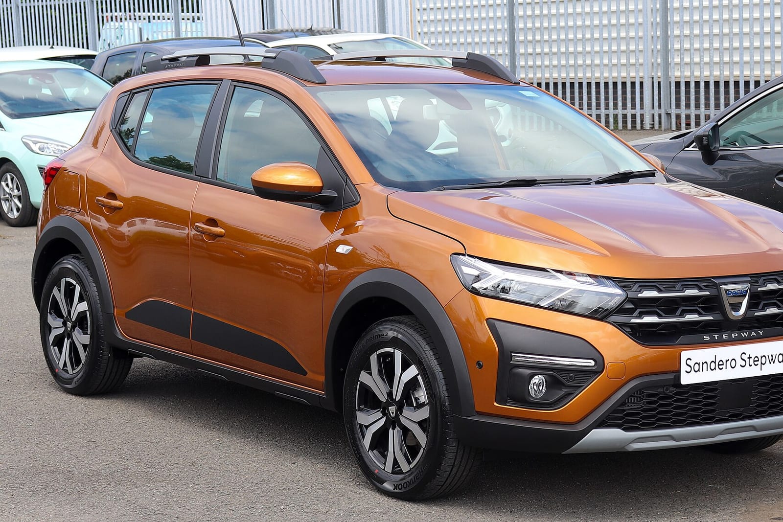 Dacia cars in a dealership with customers viewing offers